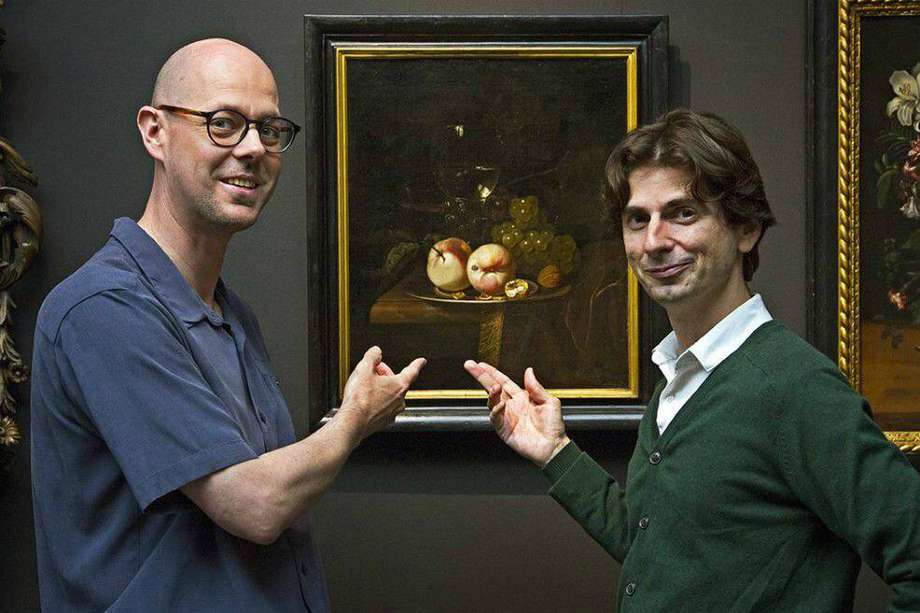 El biólogo Ive De Smet (izquierda) y el historiador David Vergauwen (derecha) frente a un bodegón con frutas.