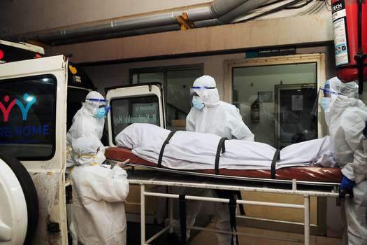 En esta fotografía tomada el 12 de septiembre de 2023, trabajadores sanitarios con equipos de protección cambian el cuerpo de una persona que murió luego de ser infectada por el virus Nipah en un hospital privado en Kozikode, en el estado indio de Kerala. (Foto de AFP)