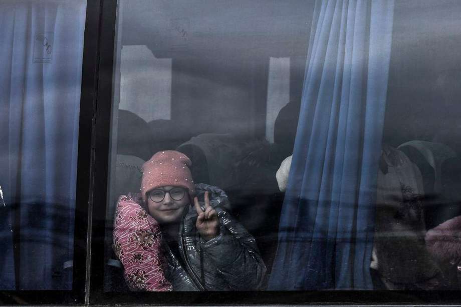 Una niña hace el signo de la victoria desde un autobús en el que ha llegado a Zaporiyia. Esta ciudad del centro este de Ucrania se ha convertido en el lugar al que llegan la mayor parte de personas que huyen de Mariúpol y las localidades cercanas controladas por el ejercito ruso.