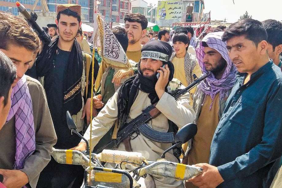 Un talibán rodeado de personas en la ciudad de Pul-e-Khumri, capital de la provincia de Baghlan. El lugar está a unos 200 kilómetros de Kabul. / AFP
