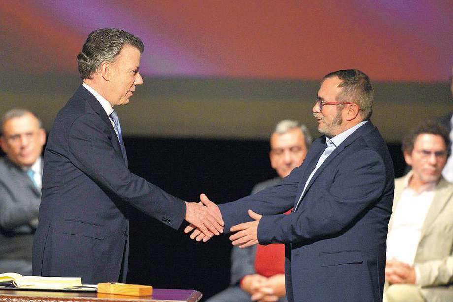 Colombian President Juan Manuel Santos (L) and the head of the FARC guerrilla Timoleon Jimenez, aka Timochenko, shake hands during the second signing of the historic peace agreement between the Colombian government and the Revolutionary Armed Forces of Colombia (FARC), at the Colon Theater in Bogota, Colombia, on November 24, 2016.
 Under pressure for fear that a fragile ceasefire could break down, the government and the Revolutionary Armed Forces of Colombia (FARC) sign the new deal and immediately take it to Congress. The plan bypasses a vote by the Colombian people after they unexpectedly rejected the first version of the deal in a referendum last month. The accord aims to end Latin America's last major armed conflict. But opponents say it is too soft on the leftist FARC force, blamed for many thousands of killings and kidnappings.
 / AFP / LUIS ROBAYO
