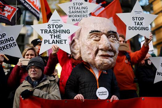 Un activista del grupo de cambio climático Extinction Rebellion (XR), con una máscara que representa a Jeff Bezos, participa en una protesta frente a la sede de Amazon en el centro de Londres el 26 de noviembre de 2021.