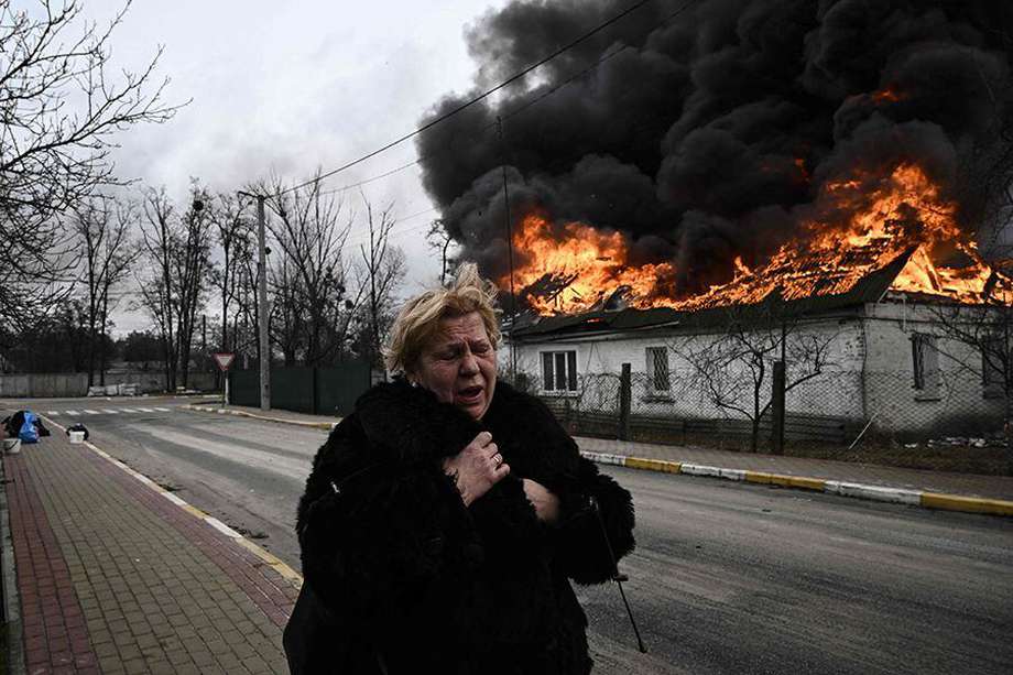 Una mujer reacciona frente a una casa en llamas después de ser bombardeada en la ciudad de Irpin, en las afueras de Kiev, el 4 de marzo de 2022.