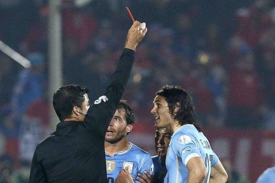 El árbitro brasileño Sandro Ricci es recriminado por el jugador Edinson Cavani luego de que lo expulsara del partido Chile-Uruguay. /EFE