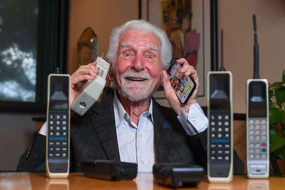 Martin Cooper, directivo de Motorola, con el prototipo del primer celular en su mano derecha y uno más moderno en su mano izquierda.