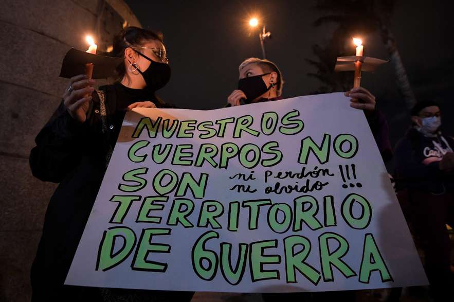 Dos mujeres sosteniendo un cartel que dice: nuestros cuerpos no son territorios de guerra