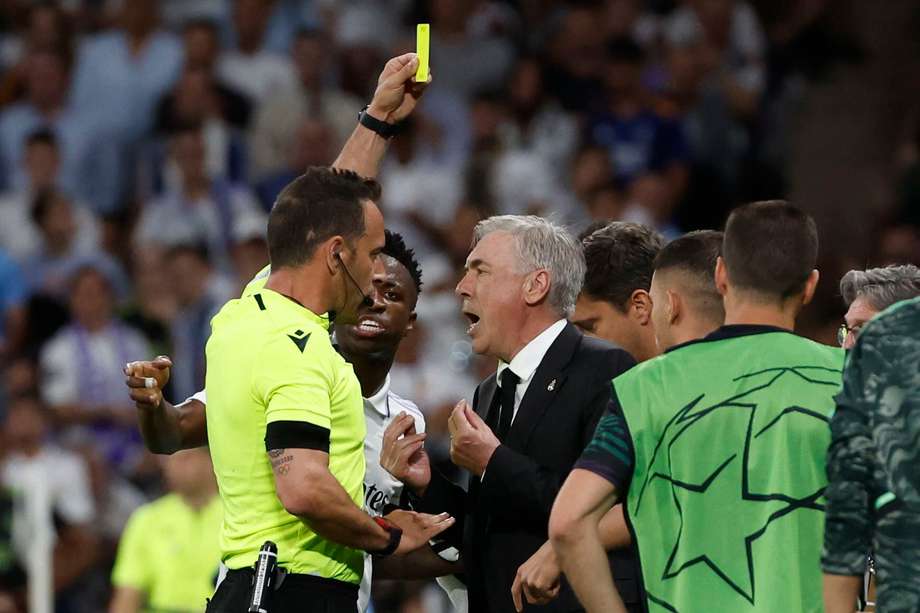 El árbitro Artur Dias (izq.) muestra una tarjeta amarilla al entrenador del Real Madrid, Carlo Ancelotti.