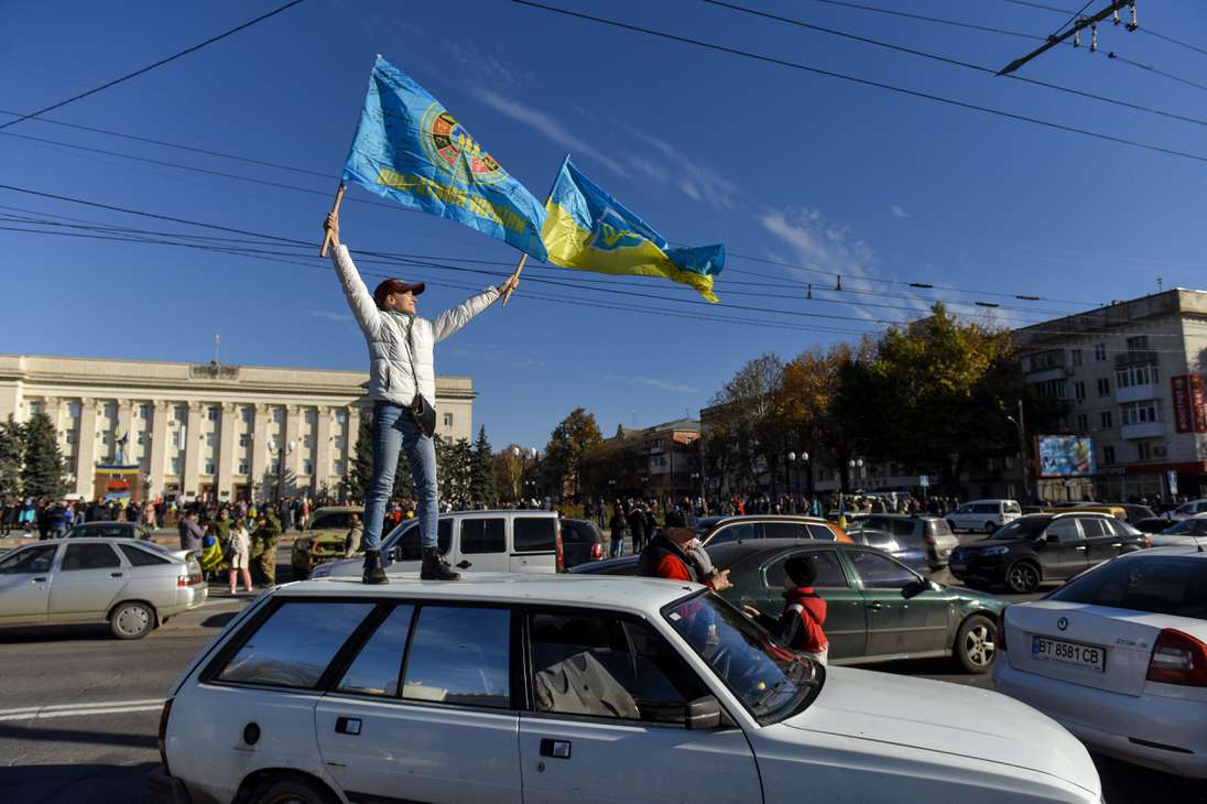 Kherson (Ukraine), 14/11/2022.- People wave Ukrainian flags atop a car during a patriotic rally after Presidnet Zelesnky's visit to the recaptured city of Kherson, Ukraine, 14 November 2022. Ukrainian troops entered Kherson on 11 November after Russian troops had withdrawn from the city. Kherson was captured in the early stage of the conflict, shortly after Russian troops had entered Ukraine in February 2022. (Rusia, Ucrania) EFE/EPA/OLEG PETRASYUK