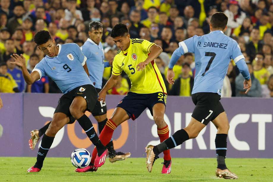 Álvaro Rodríguez (izq.) de Uruguay disputa un balón con Kevin Mantilla (cent.) de Colombia.