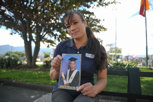 Angie Espitia sostiene una de las últimas fotos de su hermano, que se tomó el día de su grado de bachiller.