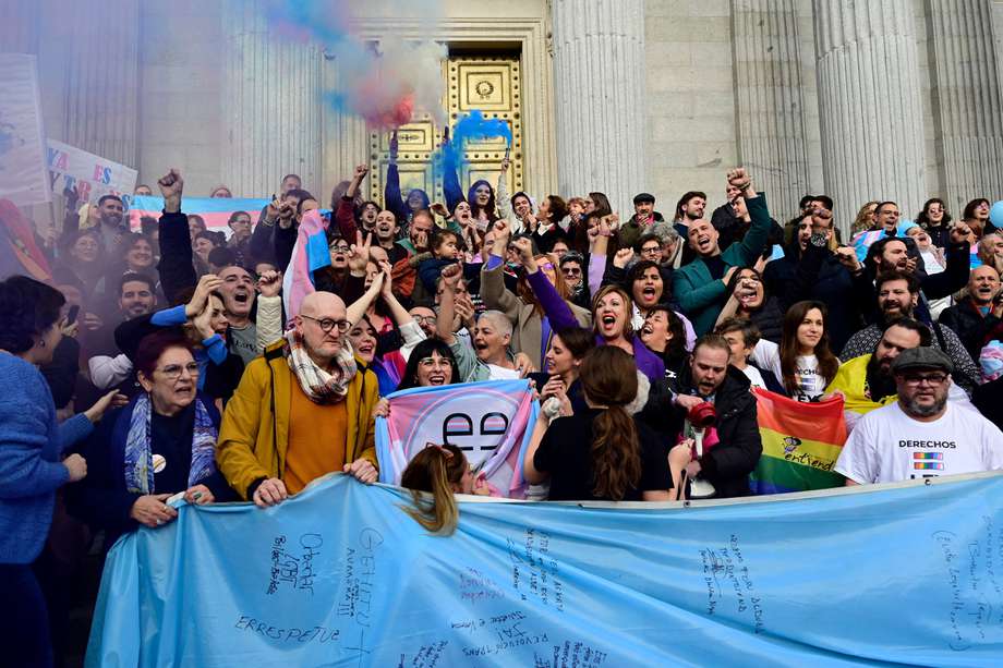 Activistas encienden bengalas mientras se reúnen para celebrar después de una votación a favor de un proyecto de ley de derechos de las personas transgénero frente al Congreso de los Diputados de España en Madrid.