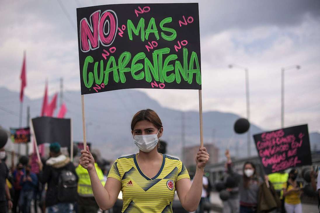 Una mujer sostiene una pancarta que dice: no más cuarentena.