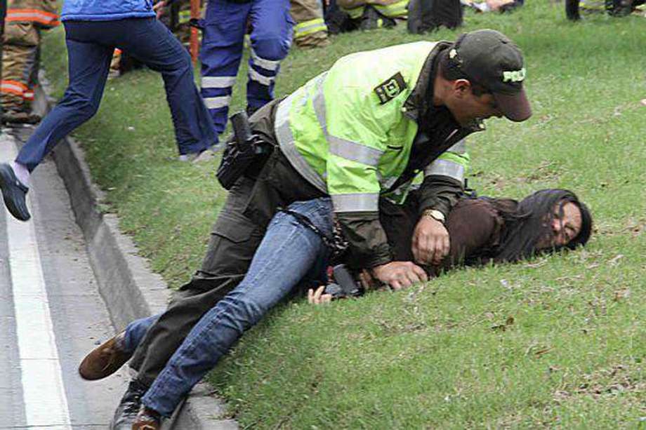 Un policía inmoviliza a Ana M. García, fotógrafa de ‘El Tiempo’./ ‘El Tiempo’ - Julio Ricaurte