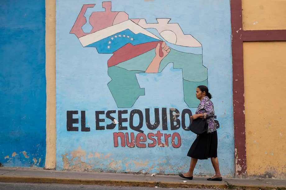 Por las calles de Caracas, Venezuela, una persona camina frente a un mural que tiene un mensaje relacionado con el Esequibo.