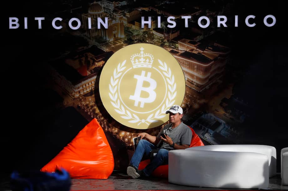 AME8533. SAN SALVADOR (EL SALVADOR), 12/11/2025.- Un hombre posa junto al logo de bitcóin este miércoles, en la plaza Gerardo Barrios, en San Salvador (El Salvador). EFE/Rodrigo Sura