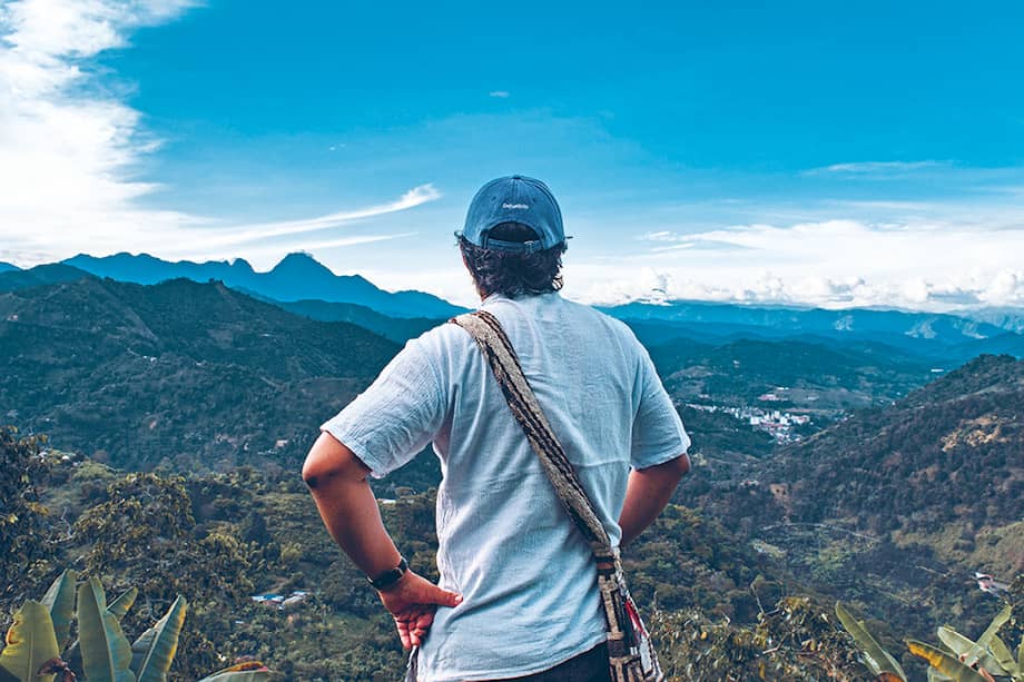 Yair Alexander Cortés Yagarí, líder juvenil del pueblo Emberá Chamí. Al fondo, el resguardo indígena de Karmata Rúa, en el suroeste antioqueño.