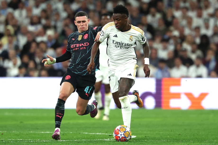 El centrocampista del Manchester City Phil Foden (izq.) compite con el brasileño del Real Madrid, Vinicius Junior durante el partido de fútbol de ida de cuartos de final de la Champions League.