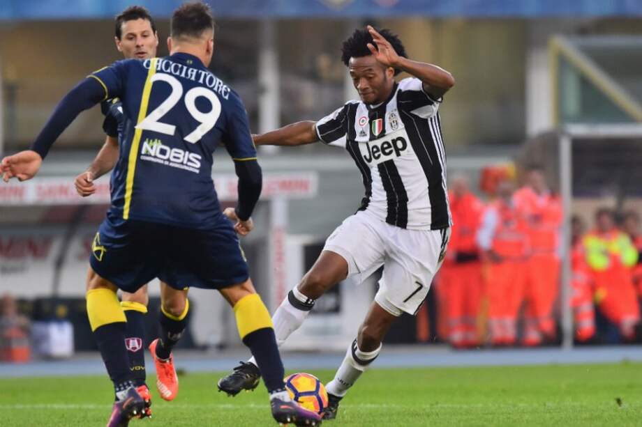 El colombiano Juan Guillermo Cuadrado (d), de Juventus, con la pelota, este domingo, en el partido contra el Chievo por la fecha 12 de la liga italiana. / AFP
