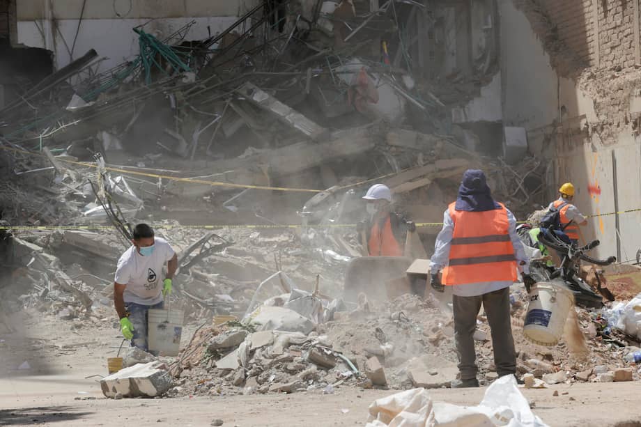 Imagen de referencia. Personas recogen escombros este viernes de una edificación destruida por el terremoto cerca a la Plaza de Bolívar de Pereira.