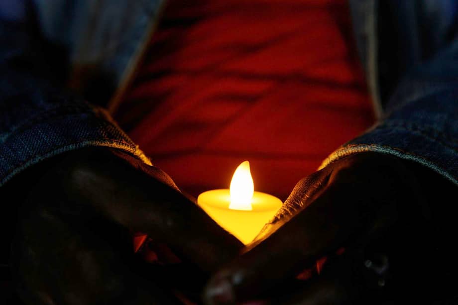 Una persona sostiene una vela electrónica encendida durante la Llama de la Esperanza junto a jóvenes de Ruanda en la ceremonia de conmemoración del 32º aniversario del genocidio tutsi.
