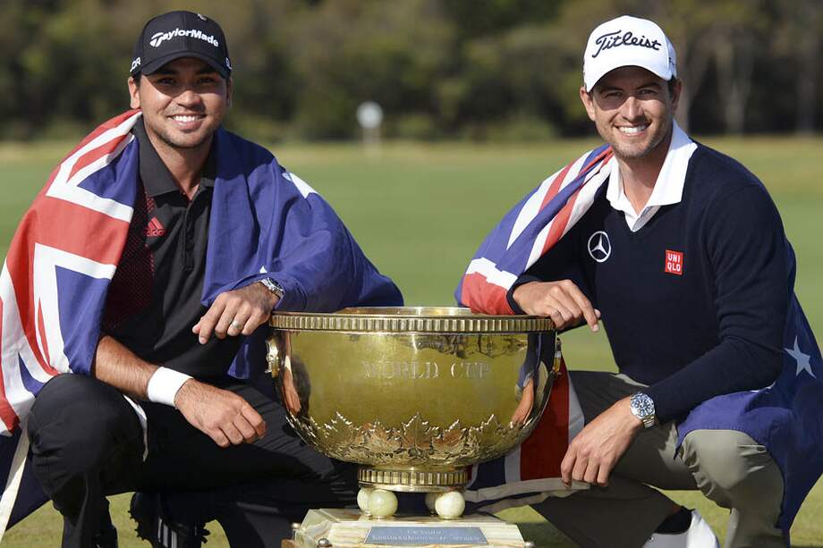 Jason Day (derecha) y Adam Scott (izquierda) posan con el trofeo de la Copa Mundial de Golf.