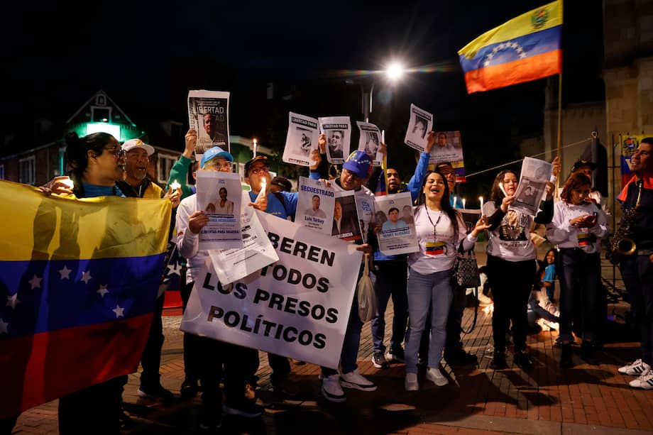 Personas sostienen carteles, banderas y velas durante la manifestación 'Marcha por la Paz y la Libertad' que exige la liberación de presos políticos en Venezuela.