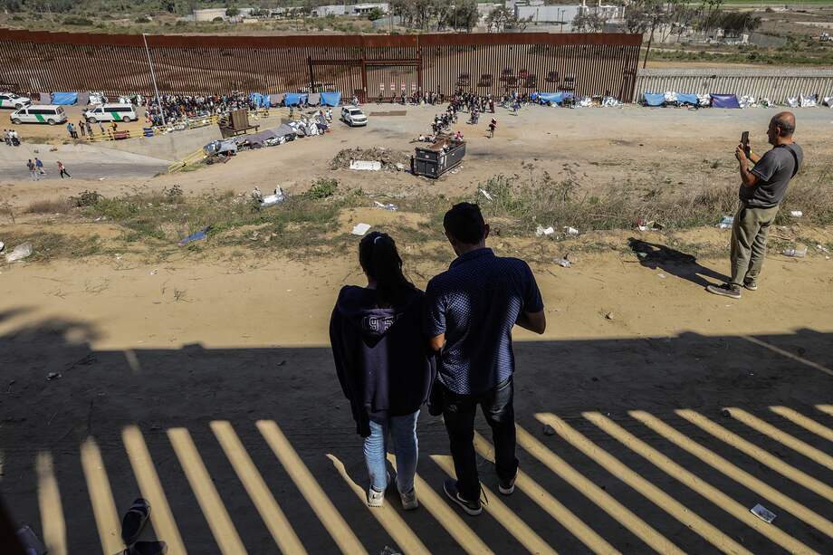 MEX5228. TIJUANA (MÉXICO), 14/09/2023.- Migrantes permanecen junto al muro fronterizo, el 13 de septiembre de 2023, en la ciudad de Tijuana, en Baja California (México). Autoridades mexicanas reconocen que el crimen organizado controla "totalmente" al menos tres puntos de cruce de migrantes indocumentados en Baja California, en la frontera de México con Estados Unidos. EFE/Joebeth Terríquez