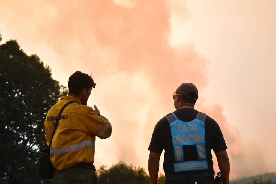 Un bombero y un integrante de la Policía Comunitaria observan un incendio en Cholila, en la provincia de Chubut (Argentina).