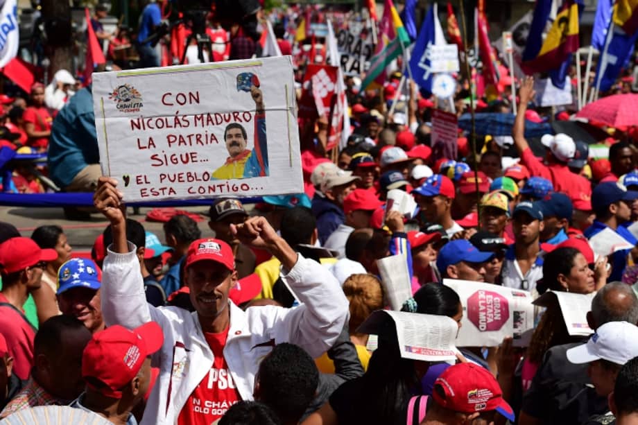 Mientras los parlamentarios debatían, una marcha de chavistas expresaban su respaldo a Maduro en Caracas. / AFP