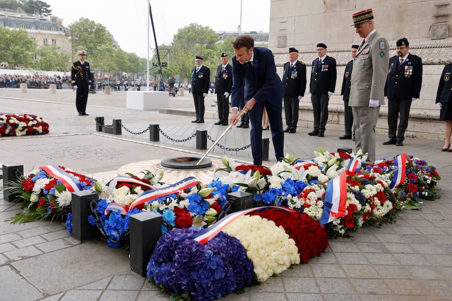 El presidente de Francia, Emmanuel Macron, enciende la llama de la tumba del soldado desconocido en el Arco del Triunfo durante las ceremonias que marcan la victoria aliada contra la Alemania nazi y el fin de la Guerra Mundial II en Europa (Día VE), en París, Francia, 08 de mayo de 2022.