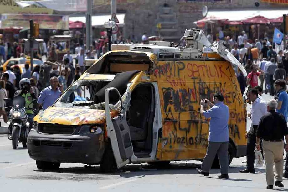 Un grupo de manifestantes pinta un vehículo dañado en las calles de Estambul. /EFE