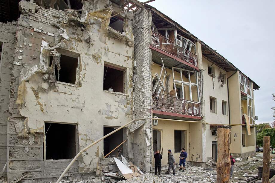Algunas personas se pararon frente a un edificio residencial dañado después de un bombardeo ocurrido el 12 de septiembre en Járkov, al noroeste de Ucrania, que ha sido clave en la ofensiva rusa.