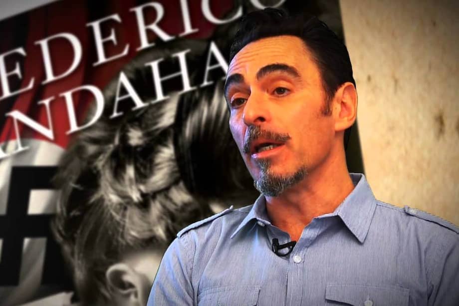El escritor argentino Federico Andahazi posa ante un afiche promocional de una de sus novelas, Los amantes bajo el Danubio. / Cortesía
