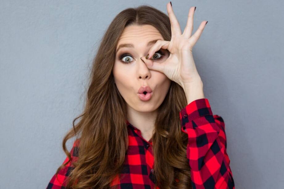 Mujer con camiseta de cuadros haciéndose un circulo en el ojo