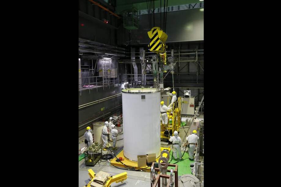 Varios técnicos revisando un contenedor del sistema de refrigeración de la piscina de combustible gastado del reactor número 4 en la planta TEPCO (Tokyo Electric Power), en Okuma, en la prefactura de Fukushima (Japón).