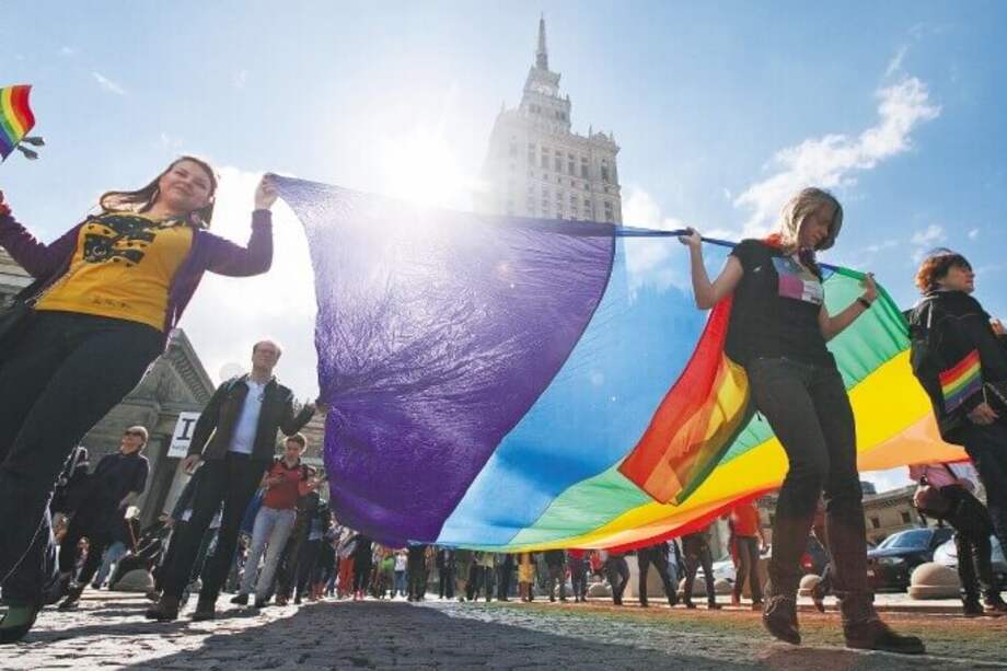 Sienten que la existencia de las personas LGBT es un ataque a las tradiciones de la sociedad, discurso que, por cierto, es compartido por muchos movimientos conservadores en el mundo y en Colombia. / Foto: Manifestantes marchan con una bandera multicolor frente al parlamento polaco - AFP.