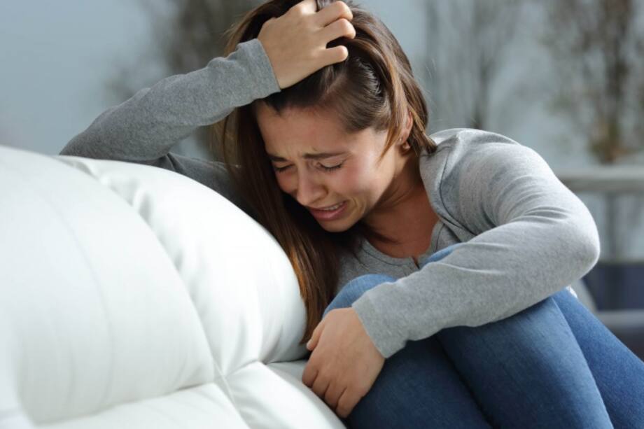 Mujer llorando en un mueble