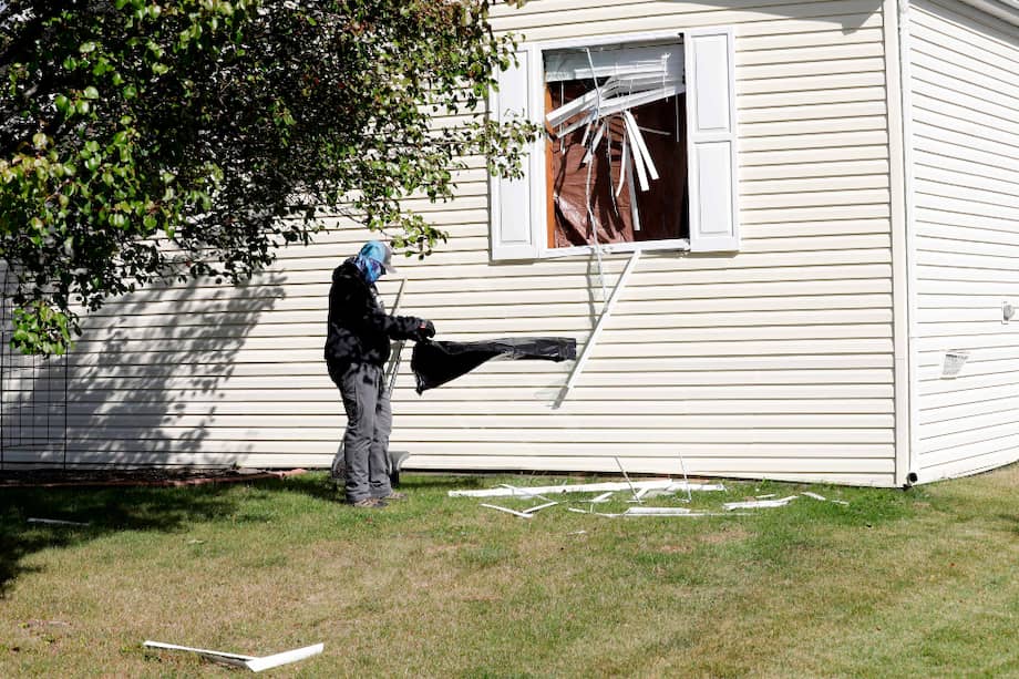 Un hombre limpia la ventana de una de las casa investigadas por el FBI.