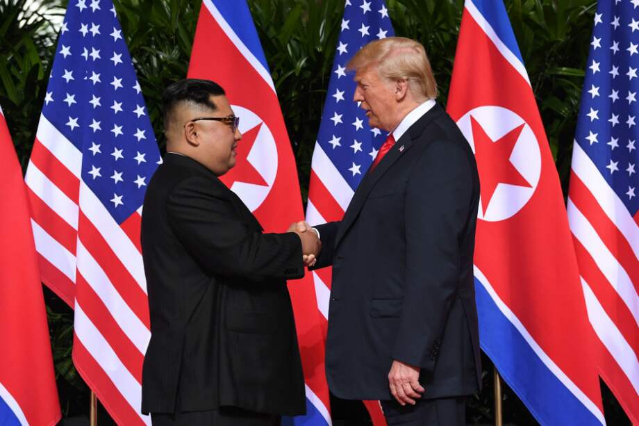 El líder norcoreano Kim Jong-un (izquierda) estrecha la mano del presidente de Estados Unidos Donald Trump en un histórico encuentro. / AFP