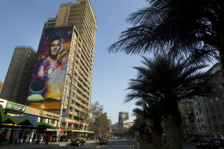 Vista de un mural con el rostro del jugador chileno, Alexis Sánchez, en Santiago de Chile. / AFP