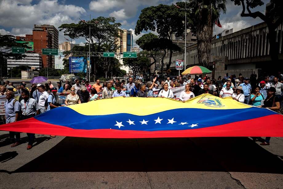 Bandera venezolana desplegada en medio de una manifestación por las calles de Caracas. EFE/Miguel Gutiérrez