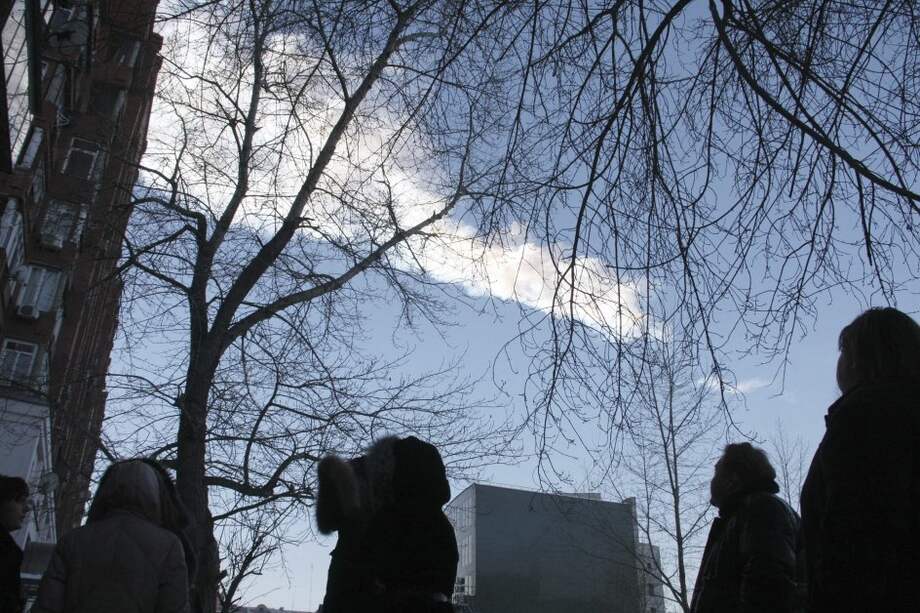Varios curiosos observan la estela de vapor que dejó el meteorito que cayó en la región rusa de Cheliábinsk./ EFE