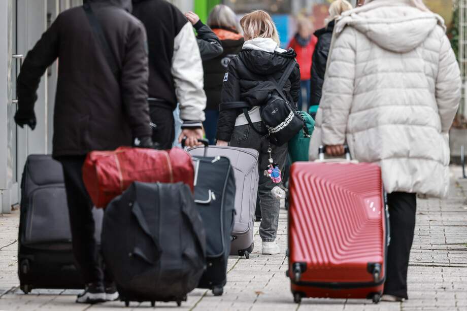Inmigrantes caminan frente al antiguo Grand City Hotel Berlin en la calle Landsberger en Berlín, Alemania.