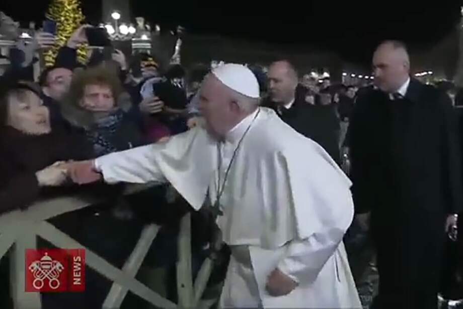 Este es el momento en que esta mujer toma al Papa bruscamente mano y lo empuja hacia ella. / AFP