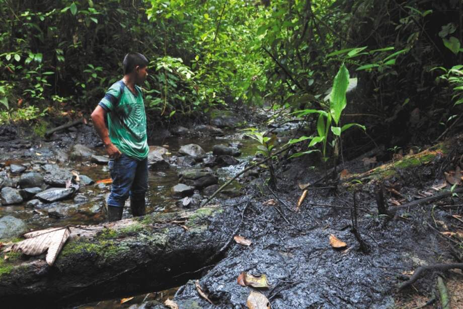 Indígena embera viendo un derrame de petróleo en Tumaco.