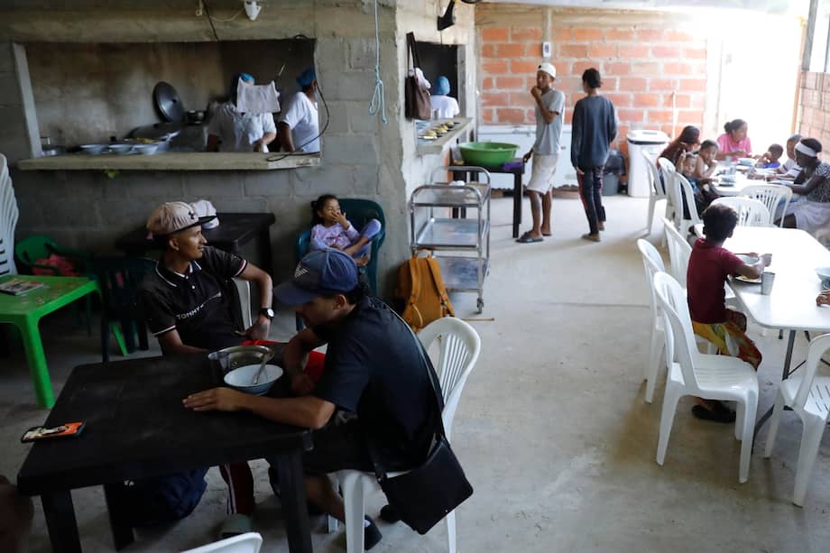 Migrantes venezolanos recibiendo alimentos en un comedor comunitario en Necoclí (Colombia).