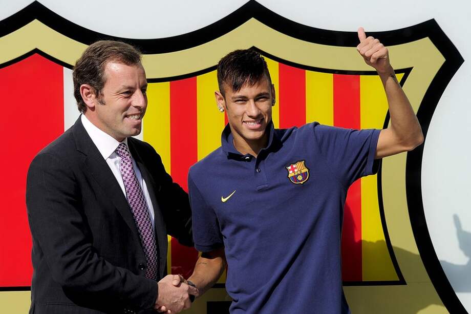 El día feliz de la presentación de Neymar como nuevo jugador del Barcelona, junto con el entonces presidente Sandro Rosell, quien tuvo que renunciar por los líos en la contratación del brasileño. / AFP