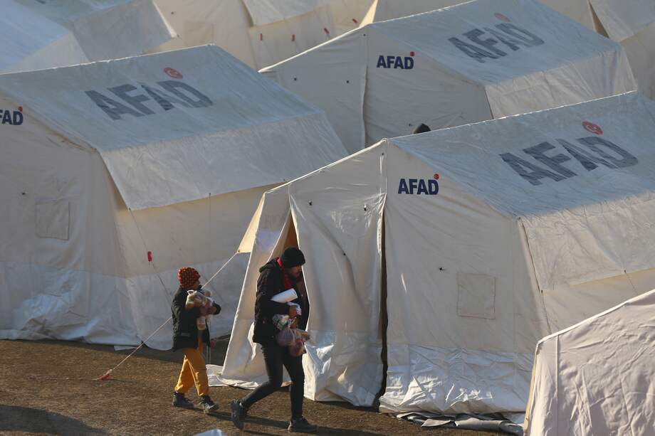 Sobrevivientes del terremoto de magnitud 7,8 caminan en los campamentos de la Autoridad de Gestión de Desastres y Emergencias, en Kahramanmarash, Turquía.