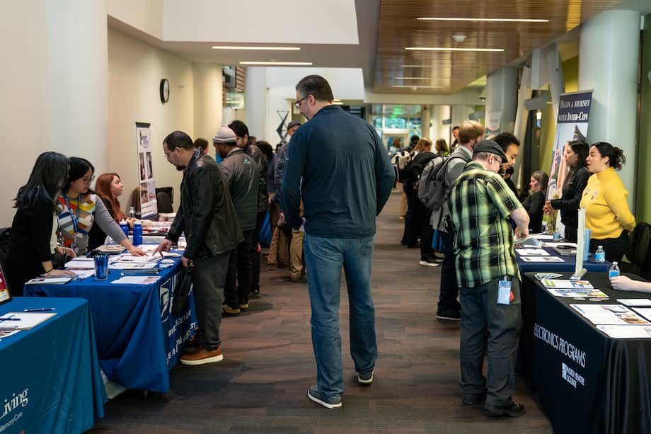 Personas que buscan empleo hablan con reclutadores durante una feria de empleo en Seattle el 10 de febrero.