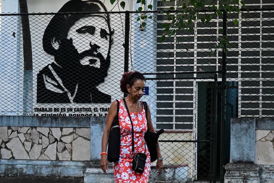 Una mujer pasa frente a un retrato de Fidel Castro en La Habana (Cuba).